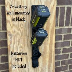 three batteries mounted on the side of a brick wall with text explaining how to use them