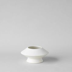 a white vase sitting on top of a table