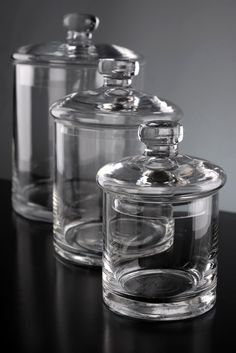 three clear glass jars sitting on top of a table