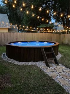 an above ground pool surrounded by string lights