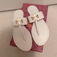 Brand New In Box Tory Burch Everly Ivory White Flat Thong Sandals With Gold Logo. Size Is 8.5 White Classic Sandals With Single Toe Strap, Classic White Sandals With Single Toe Strap, Designer White Sandals With Cushioned Footbed, White Sandals With Branded Heel Counter, White Flat Heel Sandals With Branded Heel Counter, Luxury White Sandals With Single Toe Strap, Classic White Sandals With Flat Heel, Classic White Flat Sandals, Chic White T-strap Sandals With Round Toe