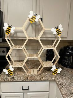 a kitchen counter with shelves made out of honeycombs on top of it and bees painted on them