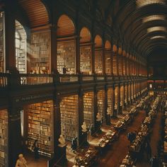 an old library filled with lots of books and people sitting at tables in front of them