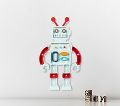 a white and red robot clock sitting on top of a table next to two letters