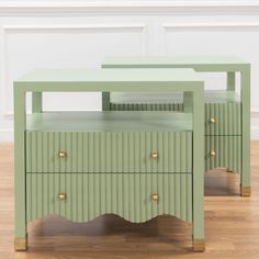 two green side tables sitting on top of a hard wood floor next to each other