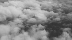 black and white photograph of clouds taken from an airplane