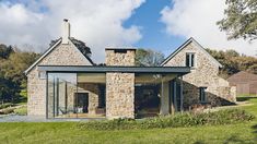 a stone house sitting on top of a lush green field