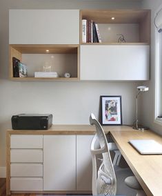 an office with white cabinets and wood floors, including a printer on a desk in front of a window