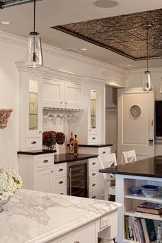 a large kitchen with white cabinets and black counter tops, along with an island in the middle