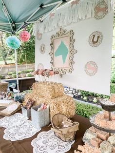 a table topped with lots of desserts under a tent