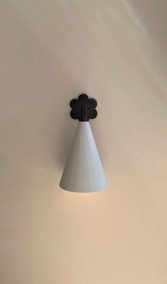 a white wall mounted light with a black and white cone on it's side