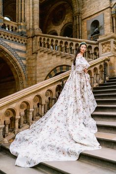 a woman in a white dress standing on some stairs