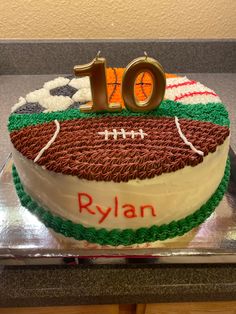 a football themed birthday cake with the number ten on it's side and an orange, green, and white frosting