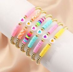 the bracelets are decorated with colorful beads and gold - plated metal accents,