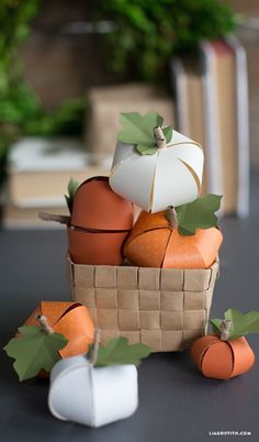 paper pumpkins and gourds in a basket on a table