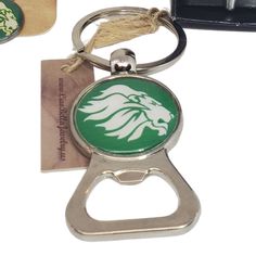 a bottle opener keychain with a green and white lion head on the front