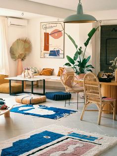 a living room filled with lots of furniture and rugs on top of a hard wood floor