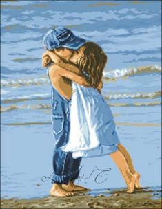 a cross stitch picture of two people hugging on the beach with waves in the background