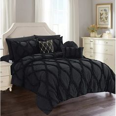 a bed with black comforter and pillows on it