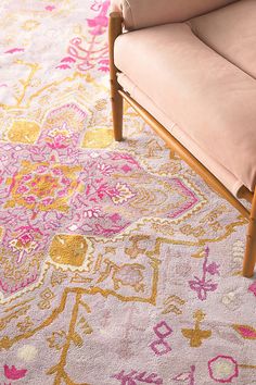 a pink chair sitting on top of a rug