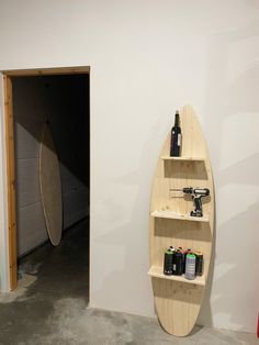 a wooden surfboard mounted to the side of a wall next to a storage unit