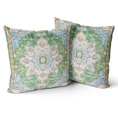 two green and blue decorative pillows on a white background, one with an intricate design