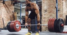 a man is lifting a barbell in the gym