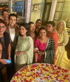 a group of people standing in front of a large cake