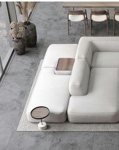 a white couch sitting on top of a rug next to a table with chairs around it