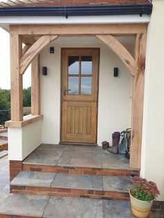 a wooden door sitting on the side of a white building