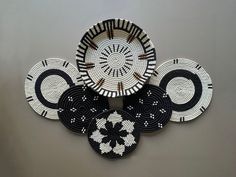 four black and white plates sitting on top of each other in the shape of circles