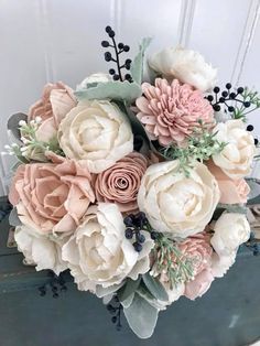 a bouquet of flowers sitting on top of a wooden table next to a white door