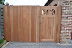 a large wooden gate next to a brick building