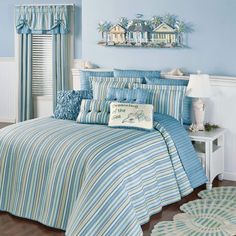 a bedroom with blue walls and striped bedding