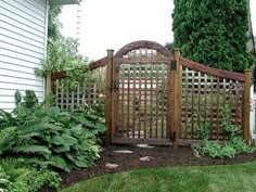 a wooden gate in the middle of a garden