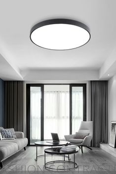 a living room with couches, chairs and a round light fixture in the ceiling