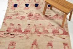 a wooden bench sitting on top of a rug next to a small table and chair