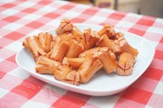 some food is on a white plate on a red and white checkered tablecloth