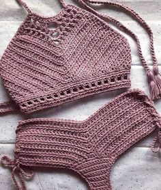 two pieces of pink crochet swimsuit laying on top of a bed