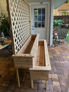 a wooden bench sitting on top of a brick patio next to a door and chair