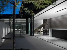 the interior of a modern house with glass walls and stairs leading up to an outdoor dining area