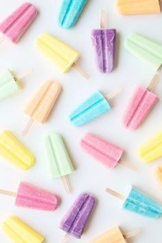 colorful popsicles are arranged on a white surface