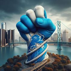 a giant blue and white hand with the detroit lions on it is in front of a cityscape