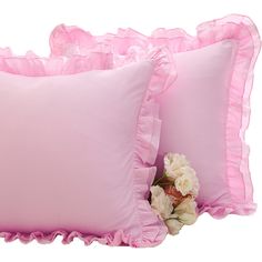 two pink pillows with ruffled edges and white flowers on the bottom one pillow has a flower in it