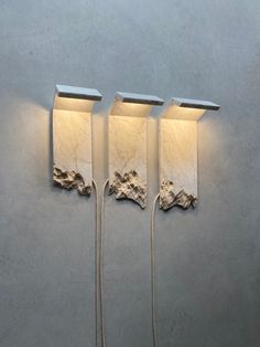 three wall lights are hanging on the wall