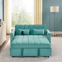 a blue couch sitting in front of a window