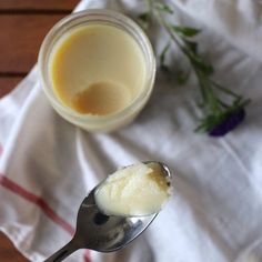 a spoon that is sitting next to a jar on a napkin with some flowers in it