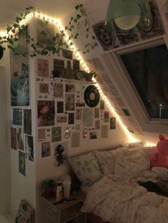 a bedroom with lights strung from the ceiling and pictures on the wall above the bed