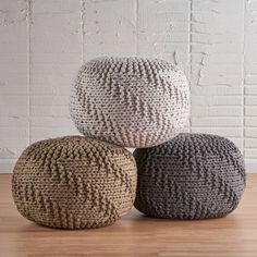 three knitted poufles sitting on top of a wooden floor