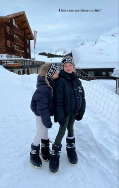 two young children are standing in the snow